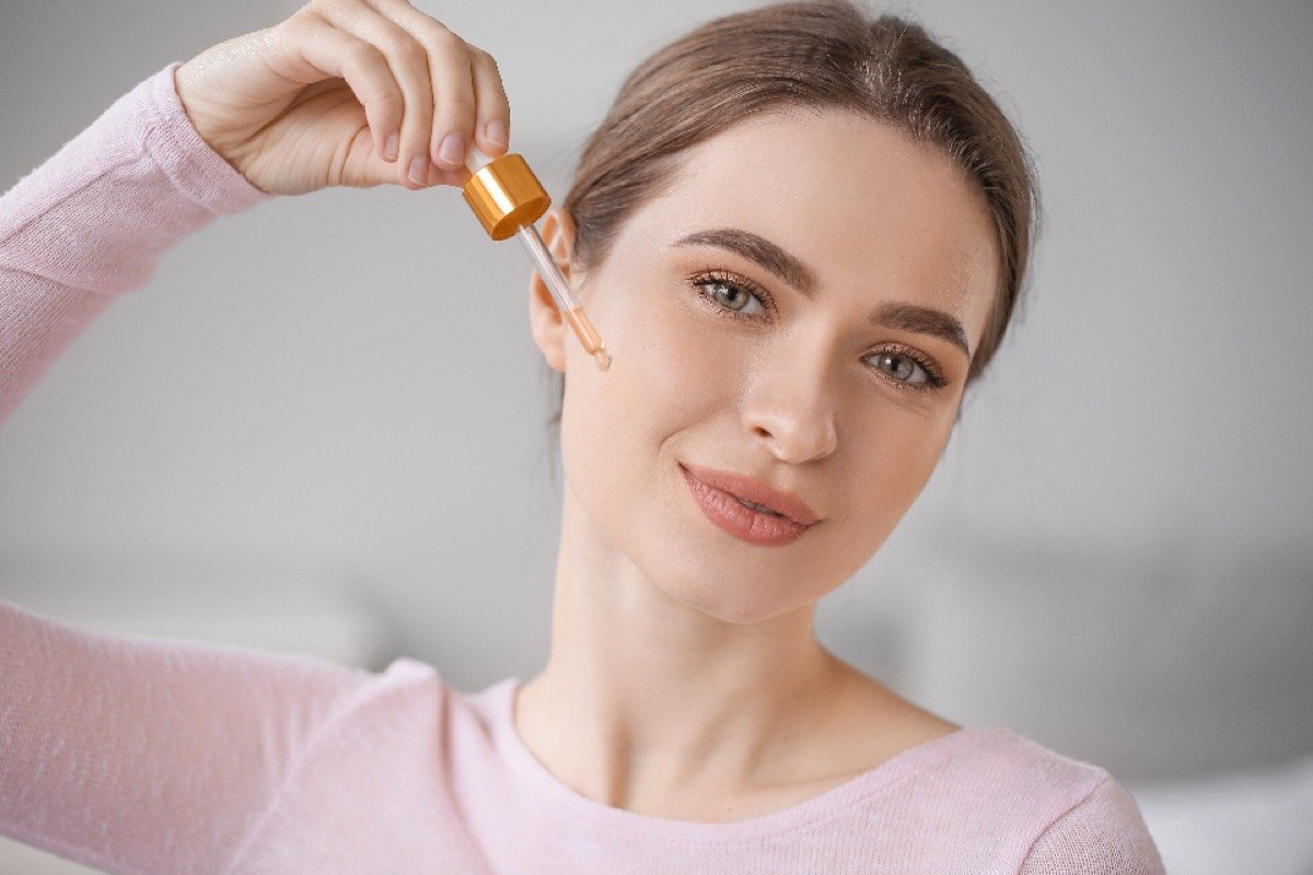 Woman applying serum with a dropper